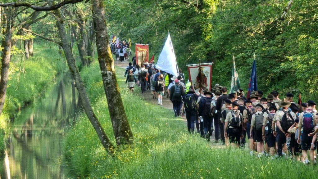 La colonne avance à travers les chemins, bannières de Chrétienté au vent